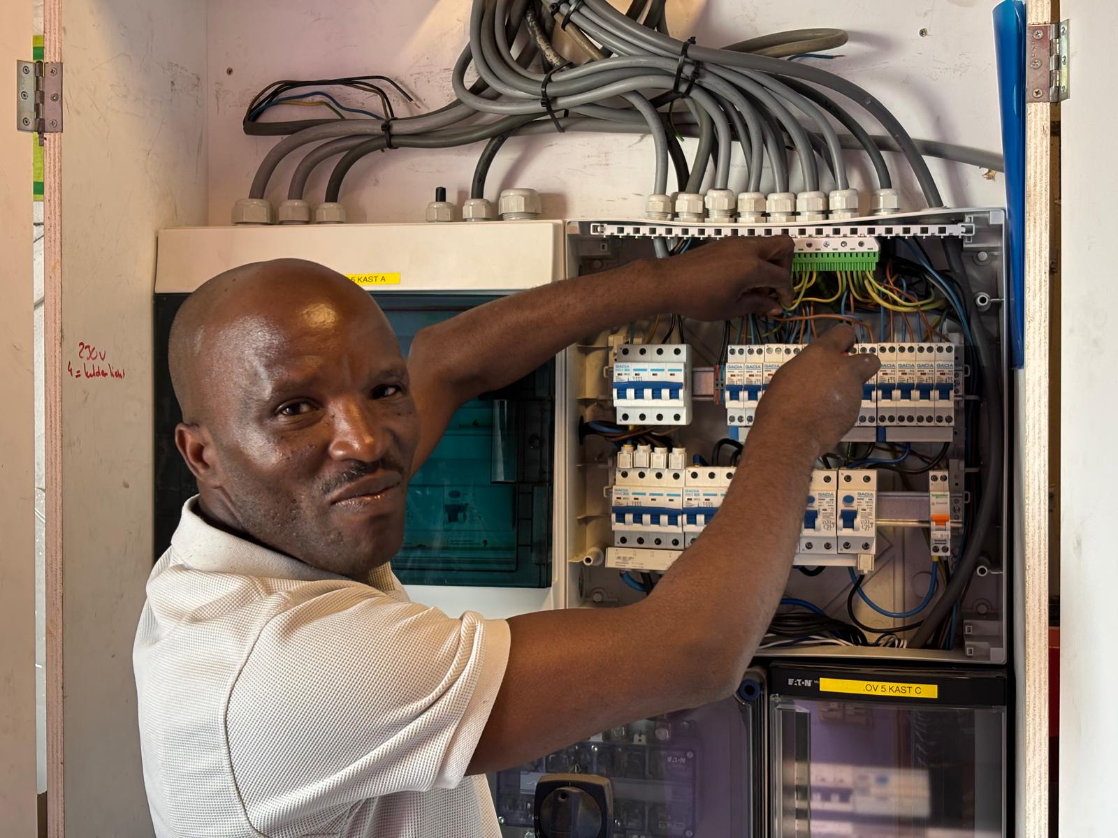 Elektricien Alain Elektra bezig met installatie van groepenkast en verdeelkast in Amsterdam